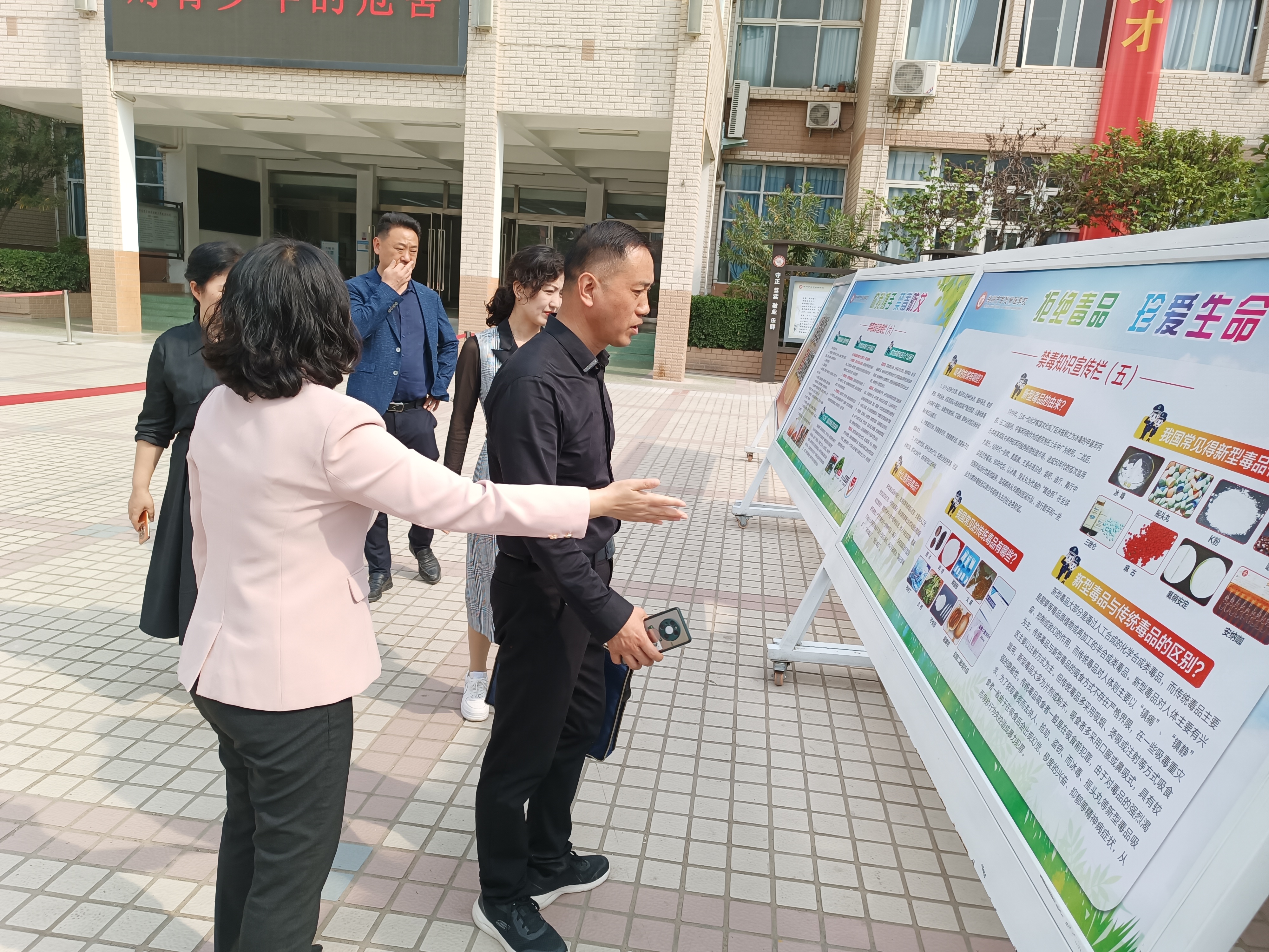 向驗(yàn)收組同志介紹學(xué)校禁毒系列展板.jpg
