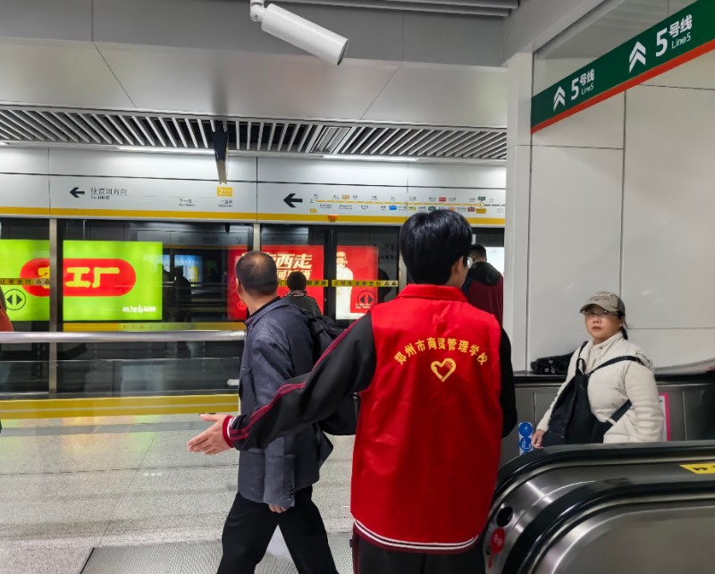 1761613590832322.jpg 志愿者學(xué)生引導(dǎo)乘客安全下扶梯.jpg